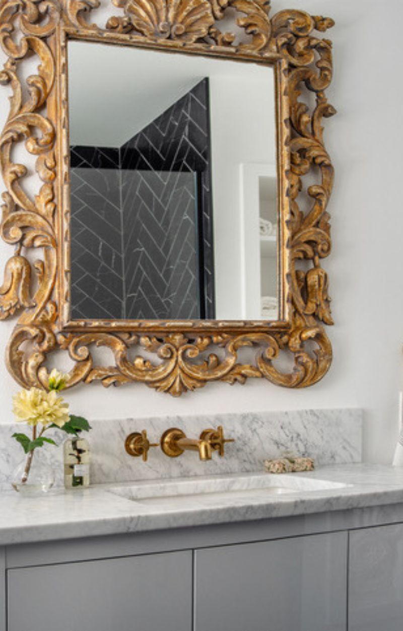 Powder room renovation with gold gilded mirror.