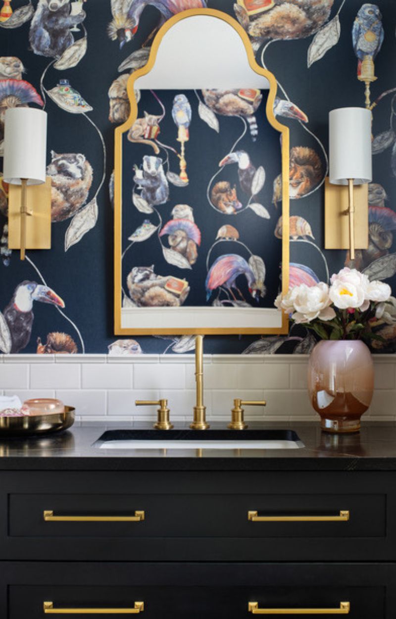 Black vanity with gold sconces and plumbing fixtures in Denver.